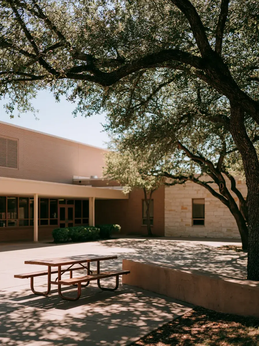 A quiet courtyard with a picnic table under a spreading live oak.