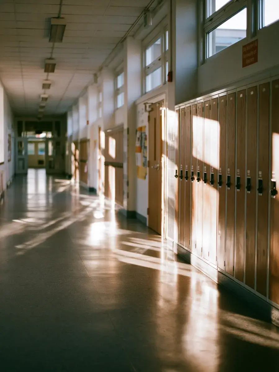 A locker corridor with window light striping the floor.