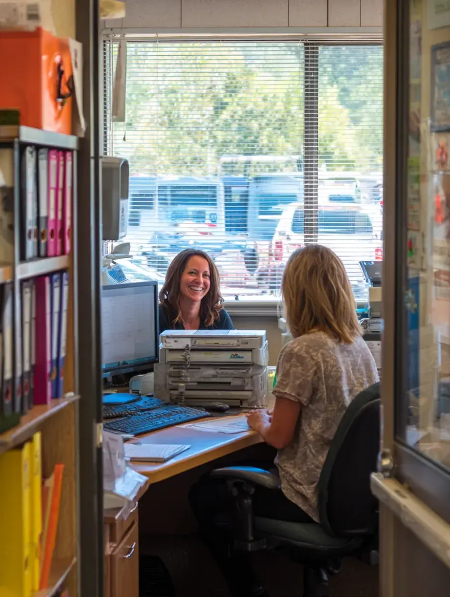 A routing coordinator's office seen through the doorway, buses out the window.